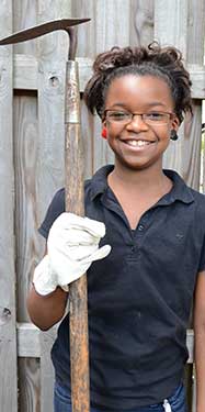 Photo: Smiling girl posing with shovel during gardening class in parks