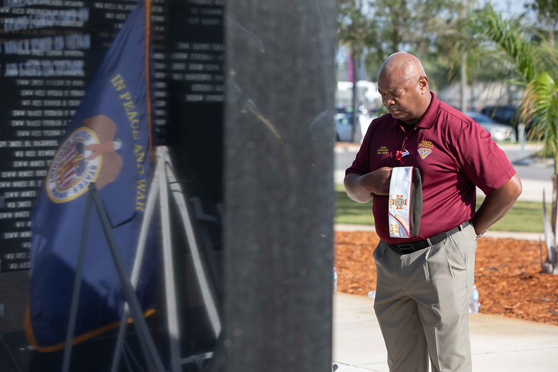 A man showing respect at Memorial Wall at Memorial Day 2026 service