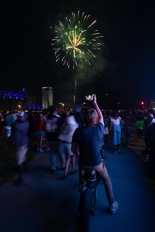 People watching and taking pictures of the fireworks at July 4th celebration