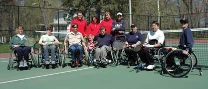 Image of people in wheelchairs posing for an adaptive tennis group photograph