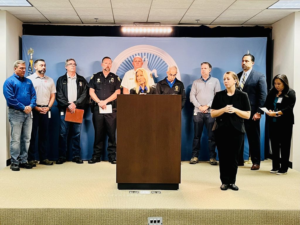 Mayor Deegan and city official standing behind podium at press conference