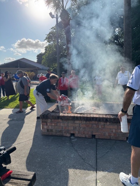 Fred Barley COJ MAVD Operations Supervisor placing flag in fire at the 250 Flag Retirement Ceremony taking place at American Legion 283