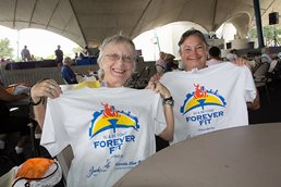 Photograph of people holding up T Shirts