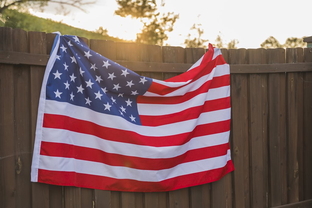 american flag hung on wooden fence