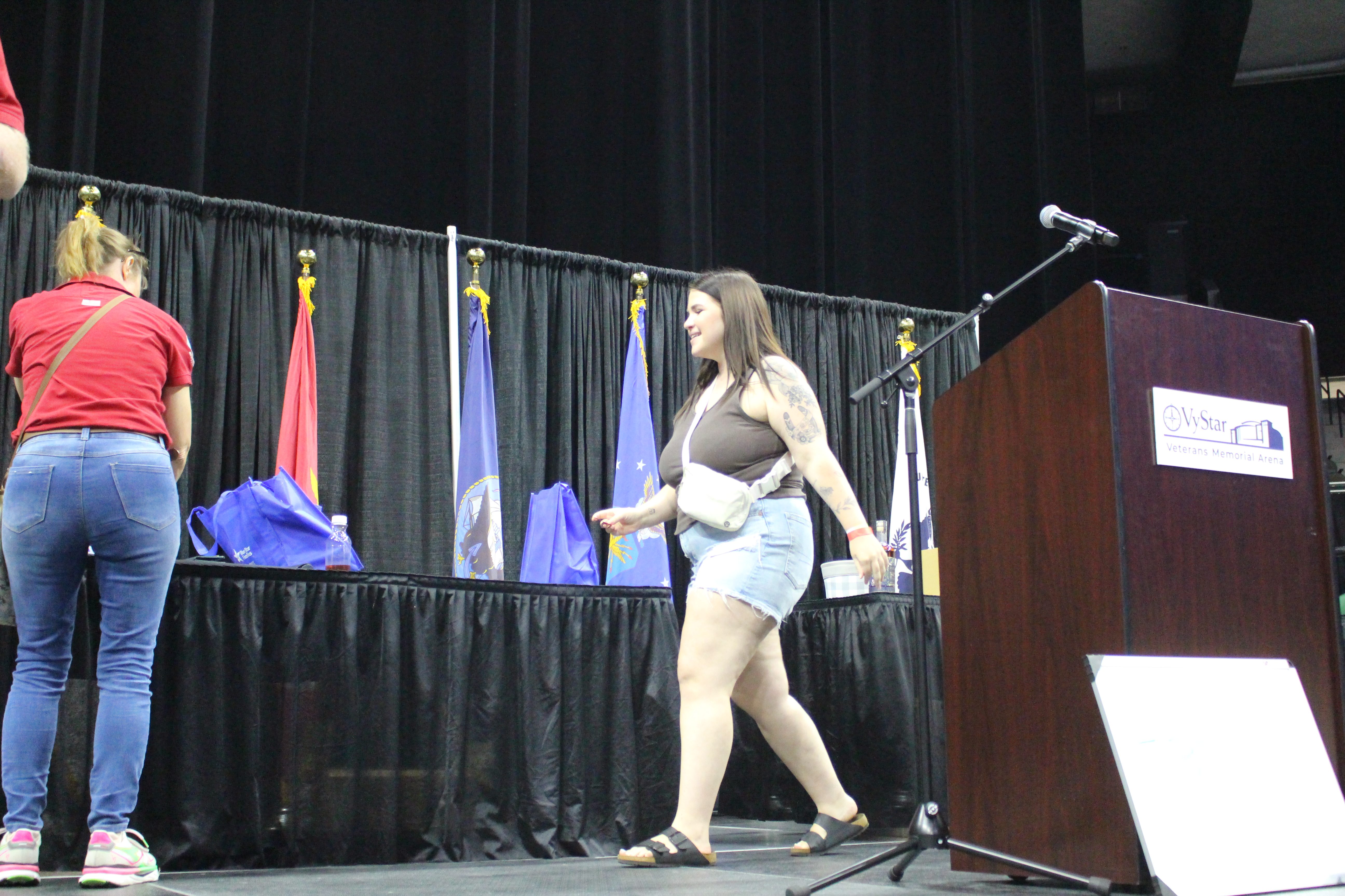 A spouse walking across the stage to pick up her gift from Tiffany Morales COJ MAVD at Spouses Night Out 2026