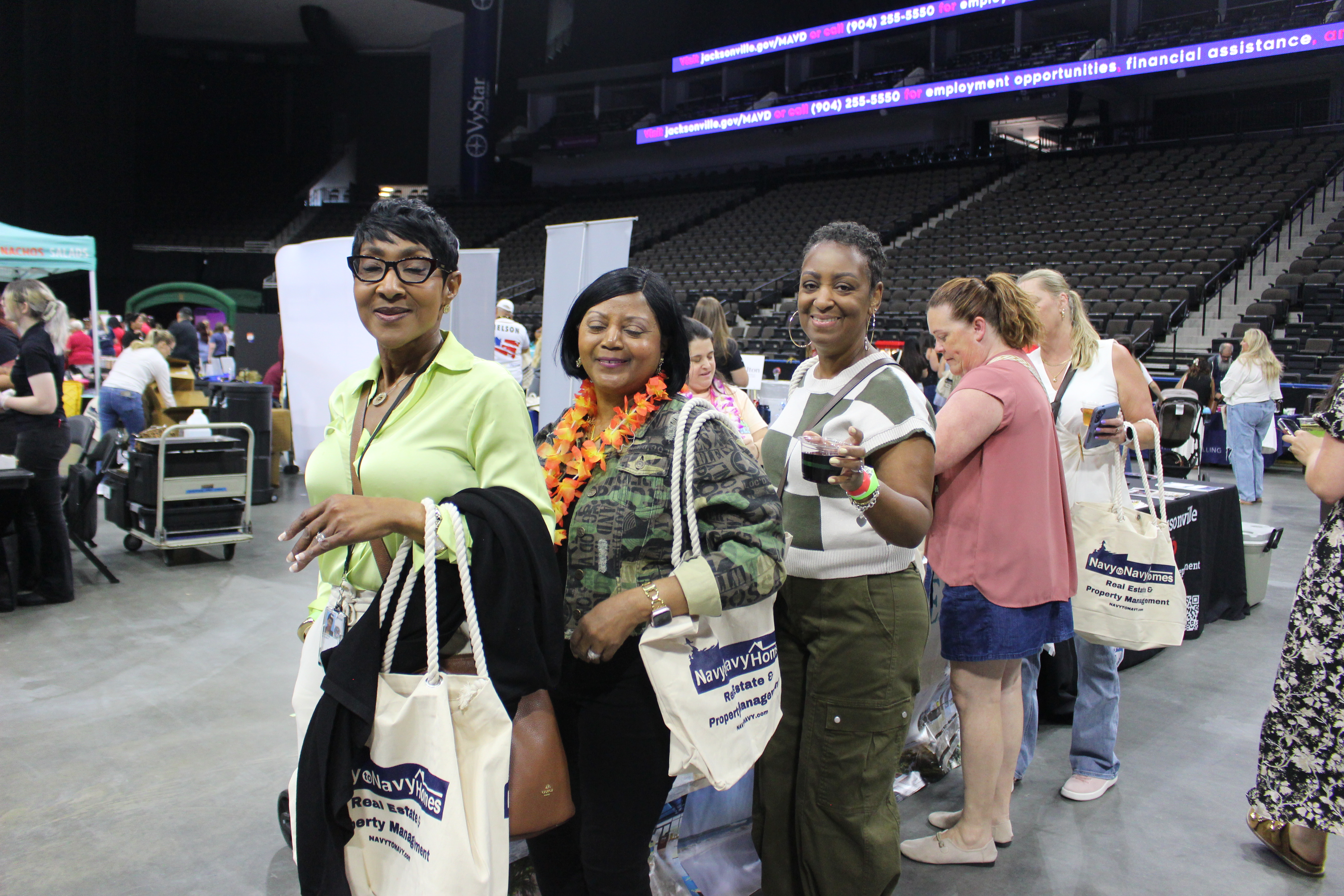 Spouses showing the new Navy to Navy carry bags they received at Spouses Night Out 2026