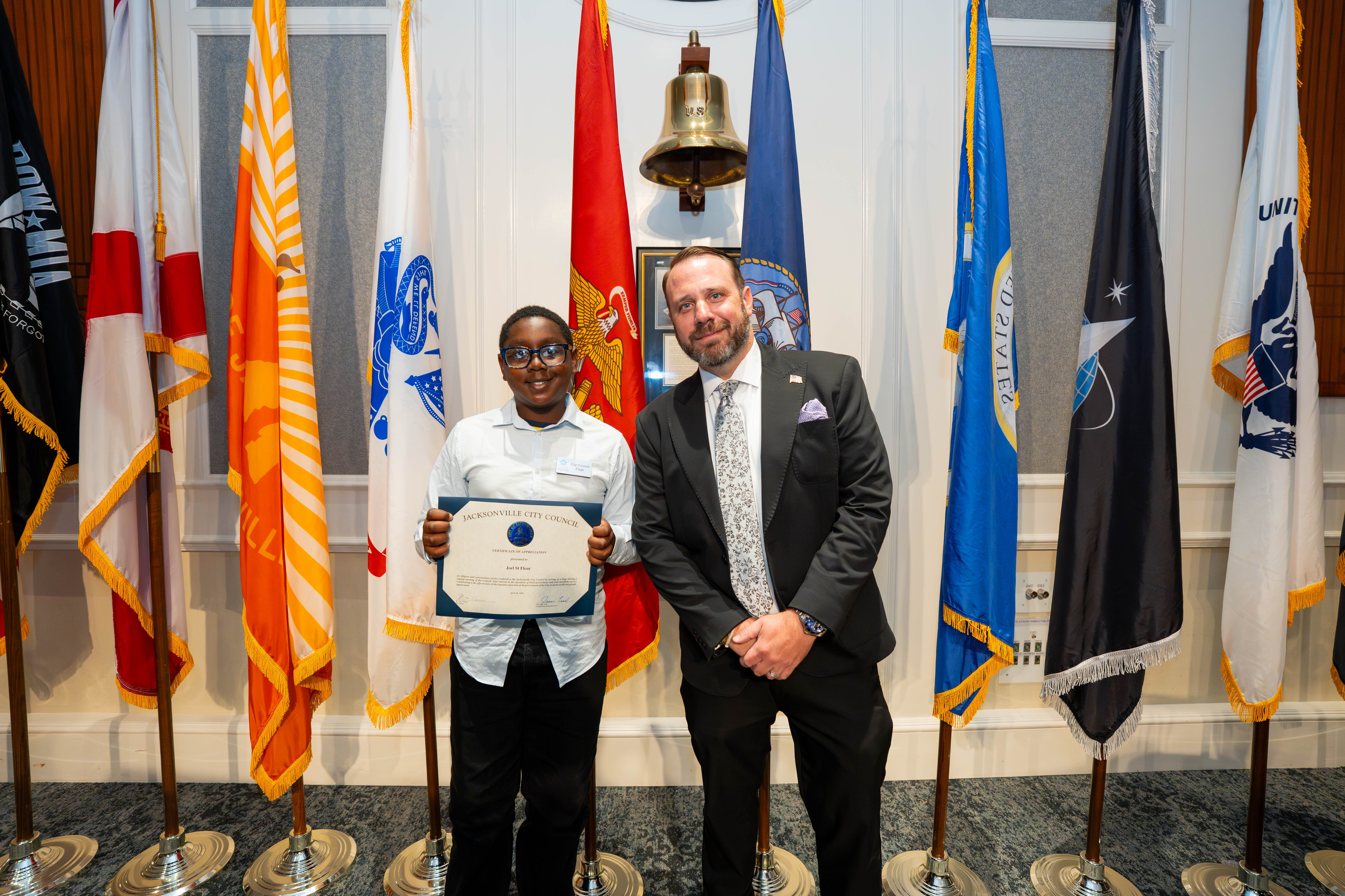 Program participant Joel St. Fleur and CP Carrico ant Stanley Zheng on April 28, 2026, at the City Council meeting.