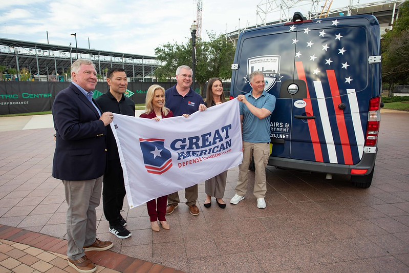 Mayor Donna Deegan, Harrison Conyers and the team from Great American Defense Communities presenting the flag dedicated to the City of Jacksonville during the Purple Heart Ceremony 2026