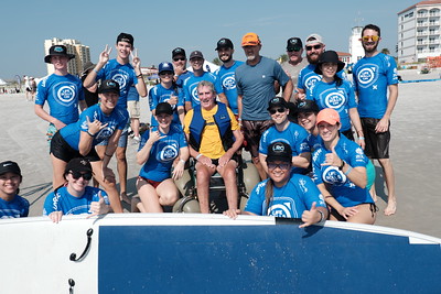 Image of a gathering of adaptive surfers posing for a group photograph