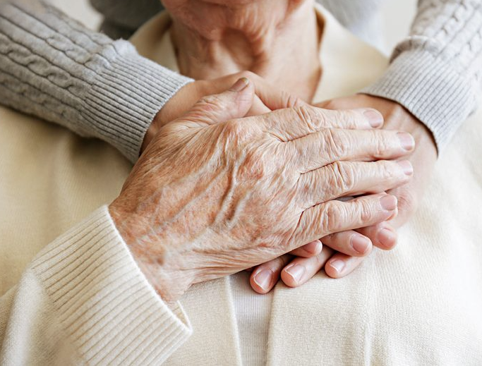 A retired couple hold hands
