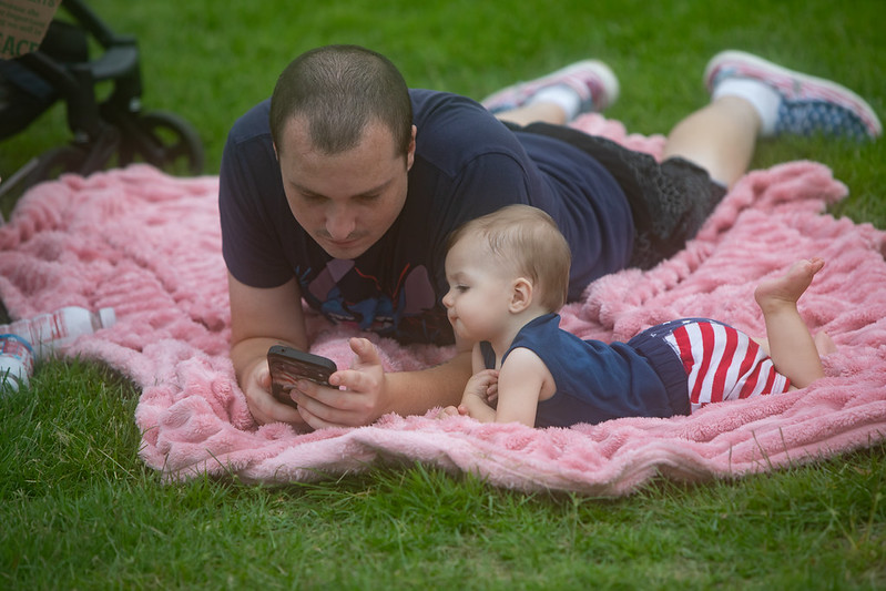 A man and child listening to music at the July 4th celebration 