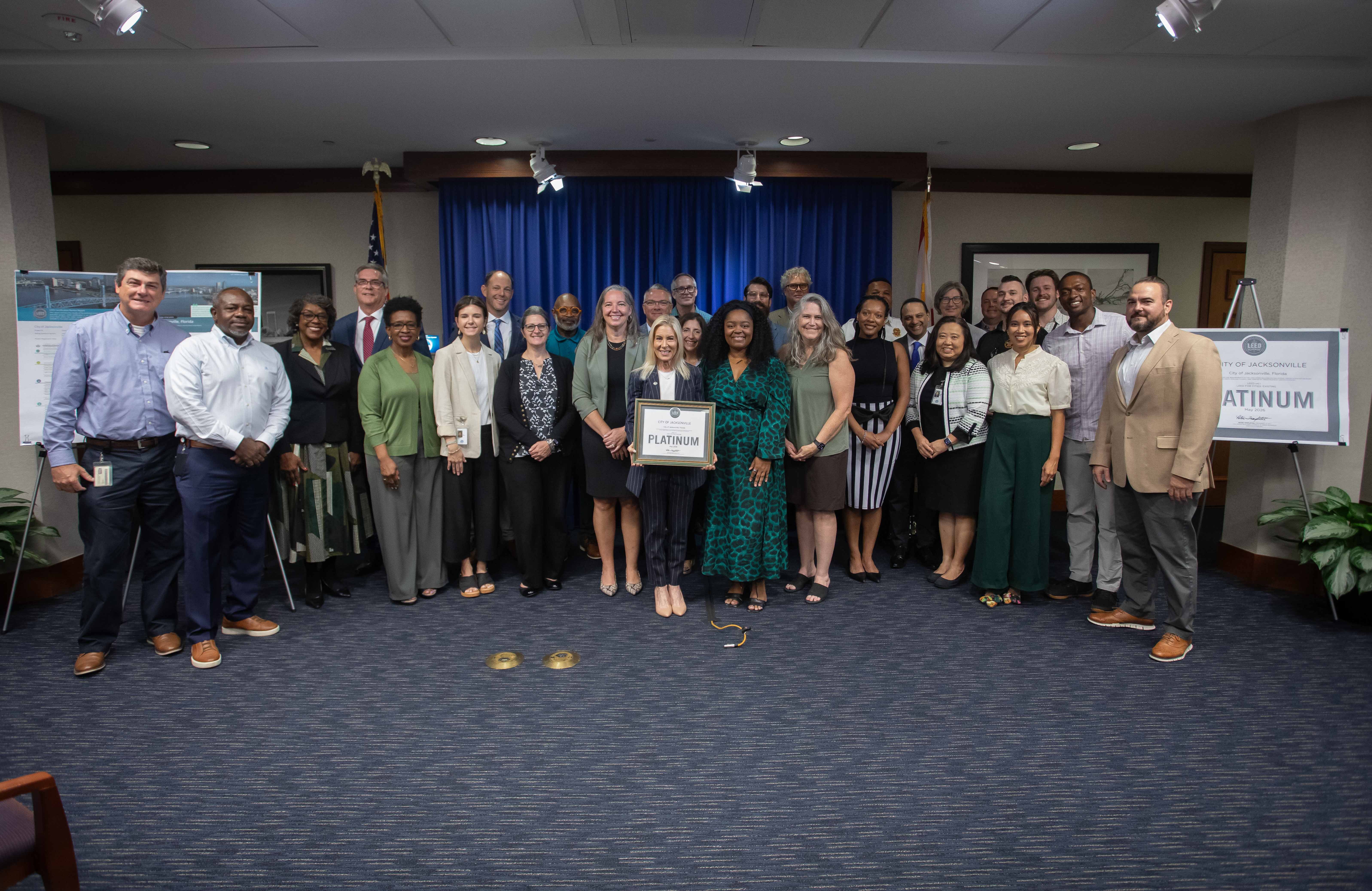 Group photo of mayor and employees holding LEEDS platinum certificate