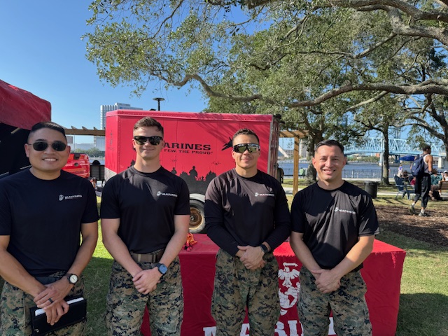 Marines standing in front of their booth with the pull up bars at Freedom Fest