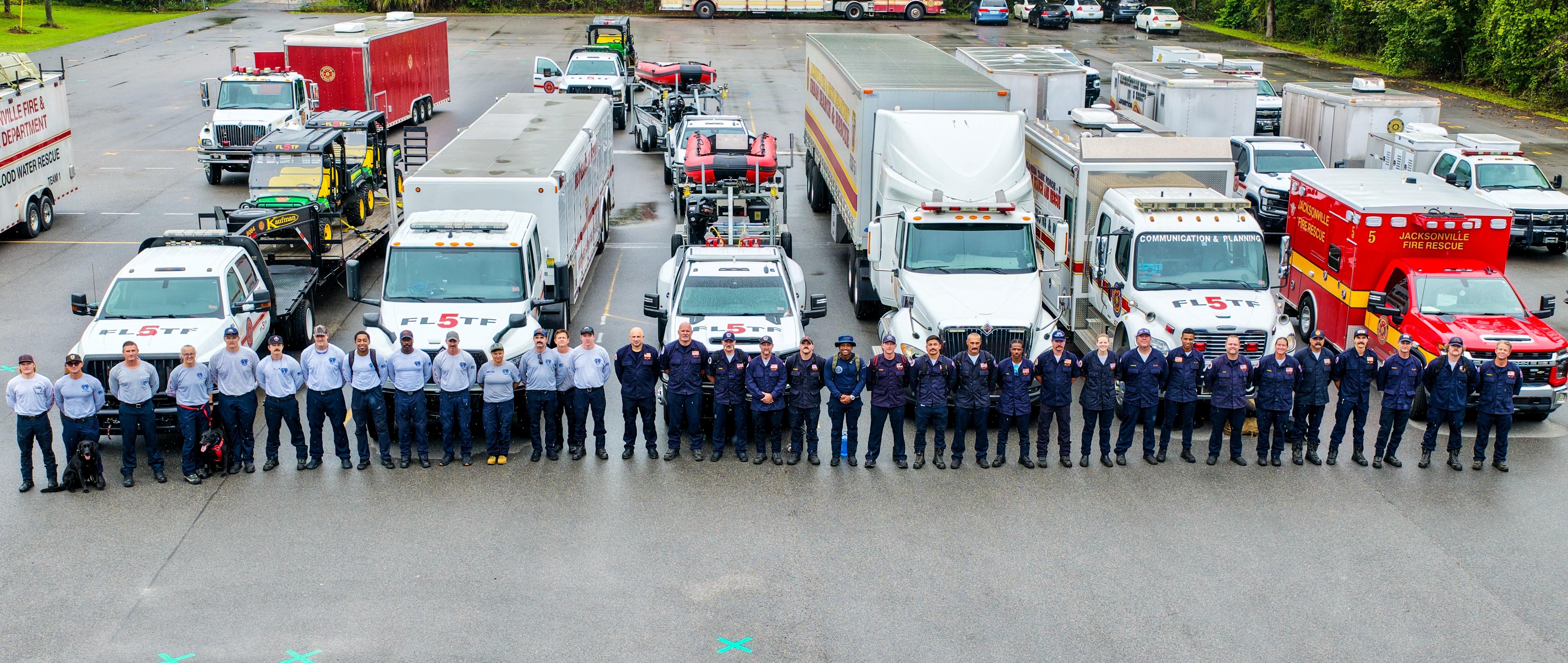 Jacksonville Fire and Rescue Department personnel stand in front of Urban Search and Rescue vehicles, boats, trailers and support equipment assembled for deployment ahead of Hurricane Isaias.