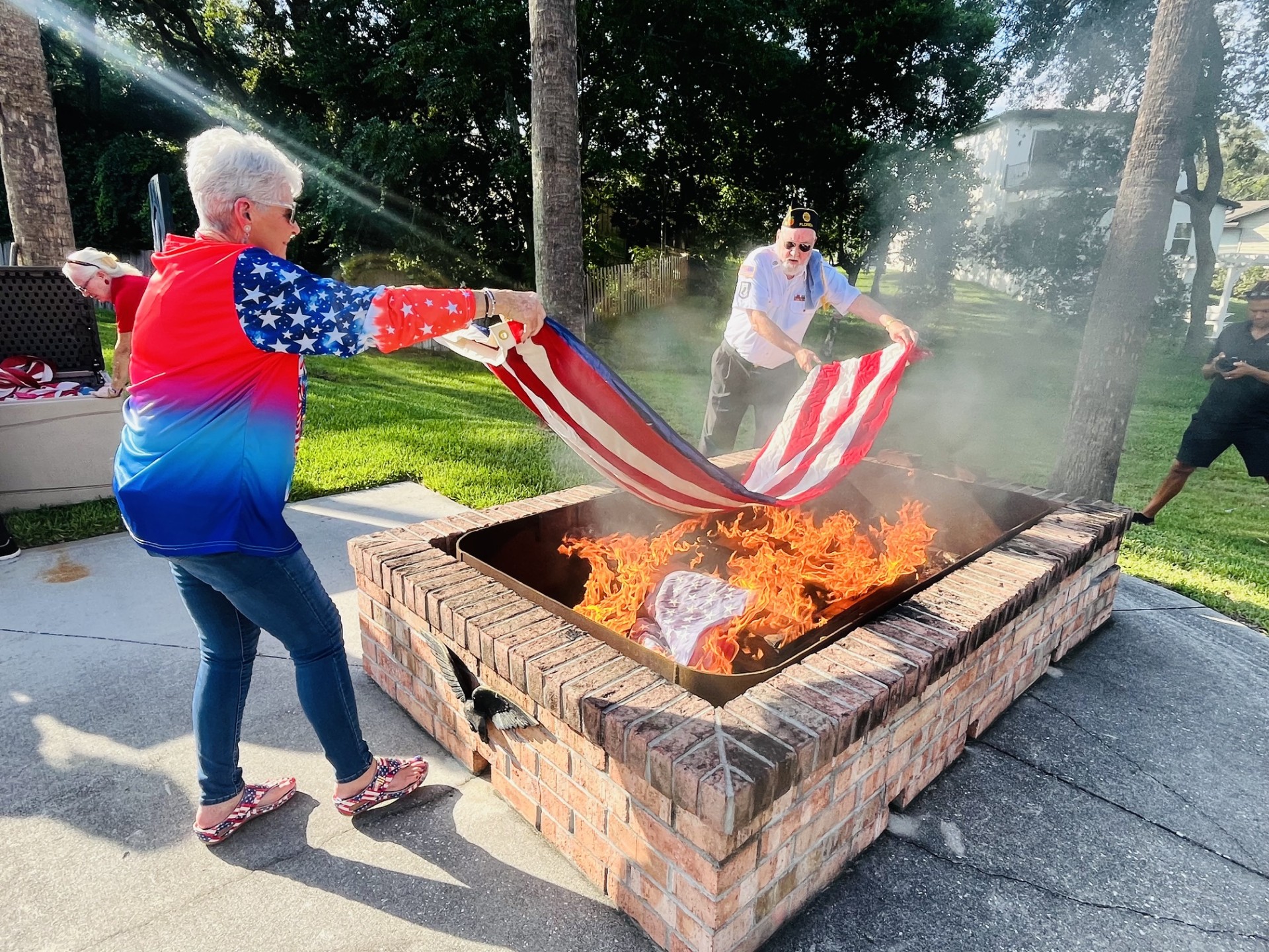 Man and woman placing flag in fire at Flag retirement Ceremony at American Legion 283 
