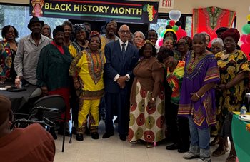 Group of people together in front of black history month sign