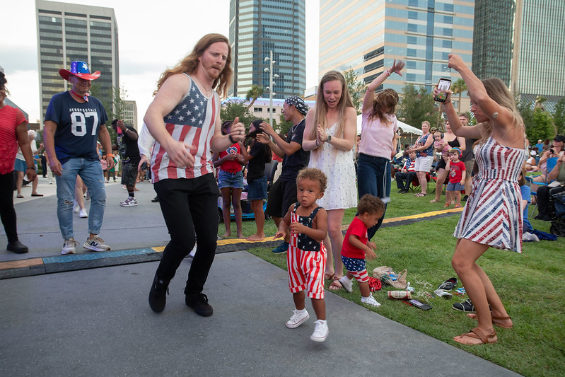 people dancing to music at the July 4th celebration 