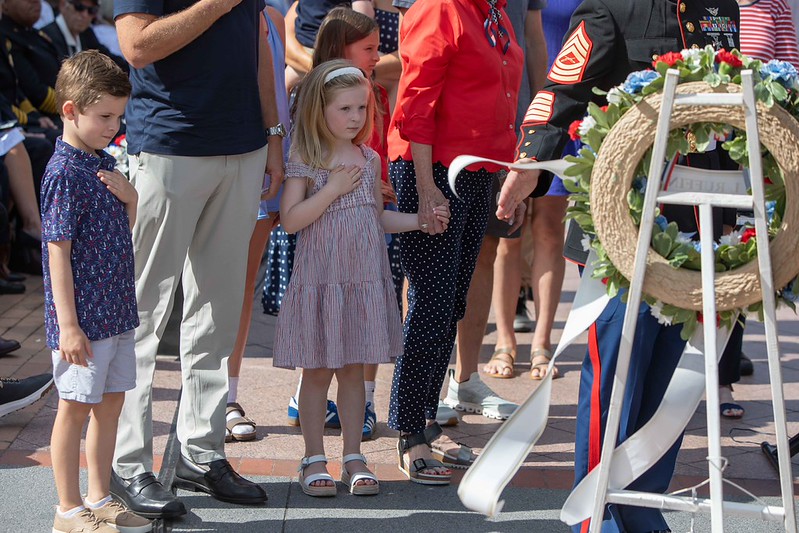 A family with hands over heart while showing respect at wreath for Memorial Day 2026