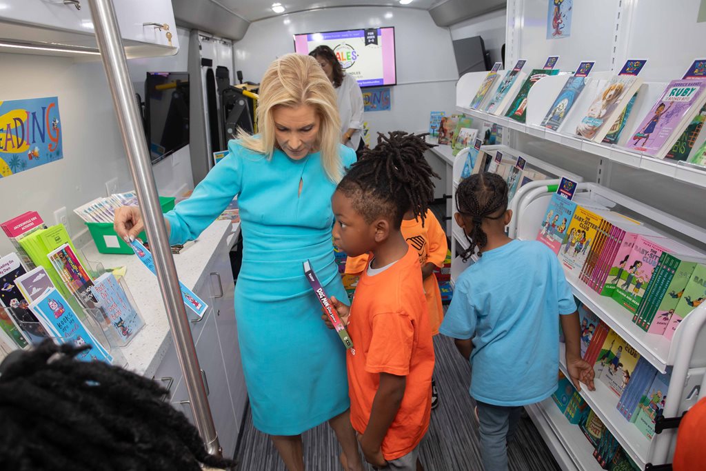 Mayor Deegan with child picking out book on bookmobile