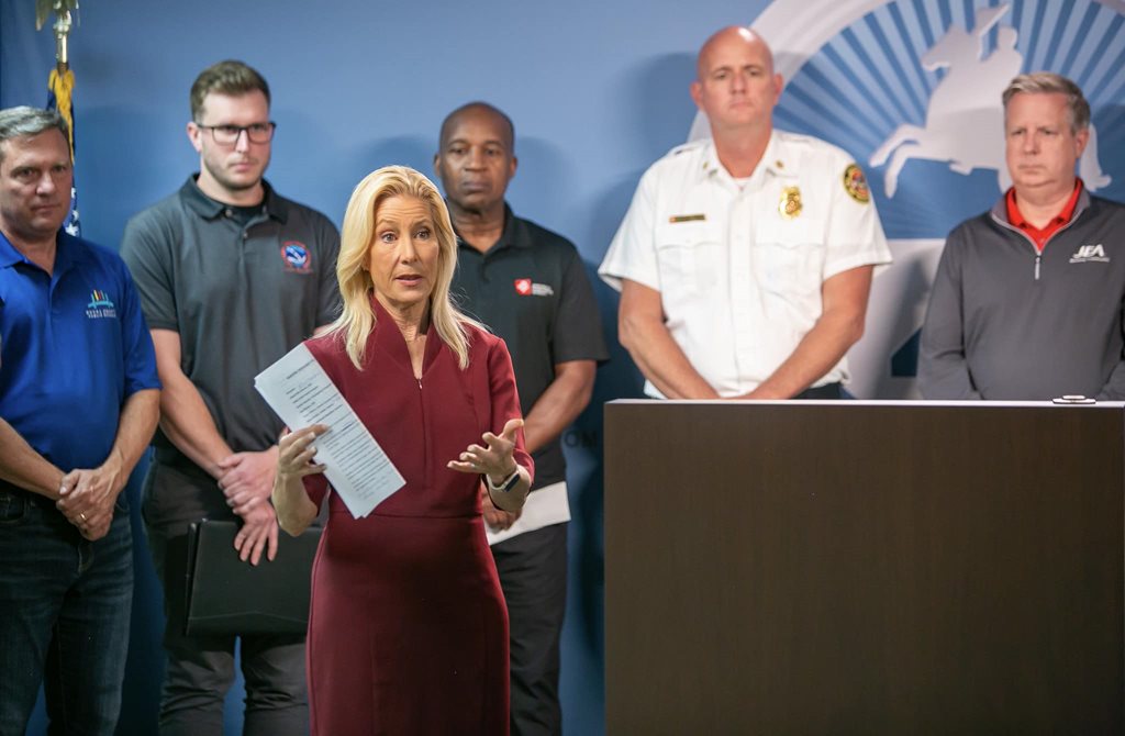 Mayor Deegan and city official standing behind podium at press conference
