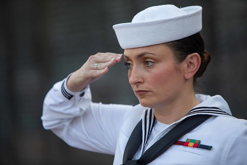 Sailor saluting the American Flag at Purple Heart Ceremony 2026