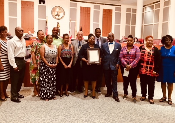 April 24, 2018 photo of Council Members Reggie Gaffney, Doyle Carter, and Reggie Brown presenting a resolution to the family of Gary Mills.