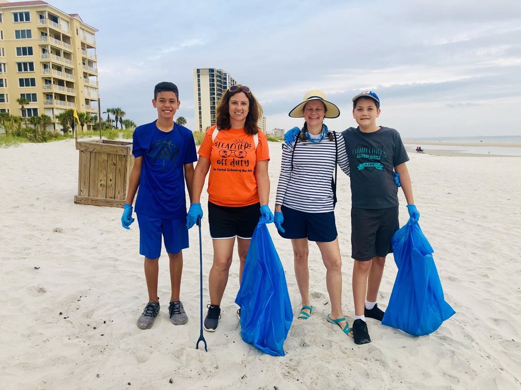 Family cleaning up t he beach during coastal cleanup event