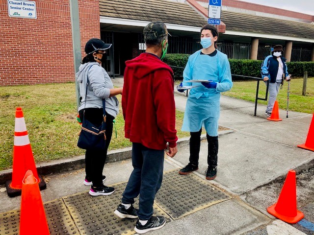 two citizens and medical worker standing outside clanzel brown community center
