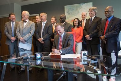 March 22, 2016 photo of City Council Members looking on as Mayor Curry signs a new agreement with JEA.