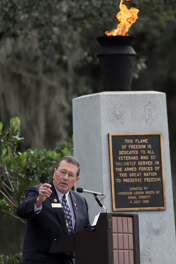 November 10, 2014 photo of Council Member Jim Love speaking in front of the Flame of Freedom during the rededication ceremony for the flame.