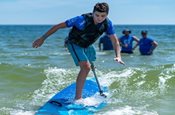 young boy with missing leg surfing