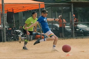 Adults playing soccer in a field
