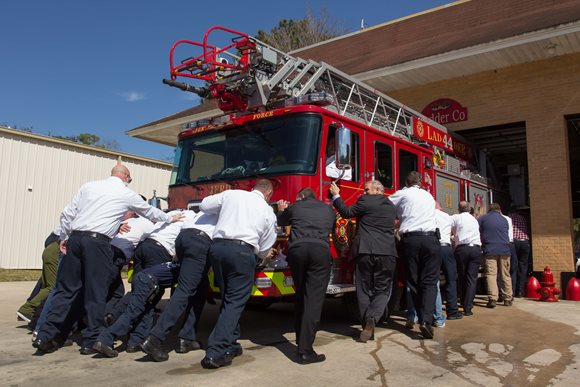 Mayor Curry and City Councilman Becton help the crew of Station 44 push the new Ladder into the bay.