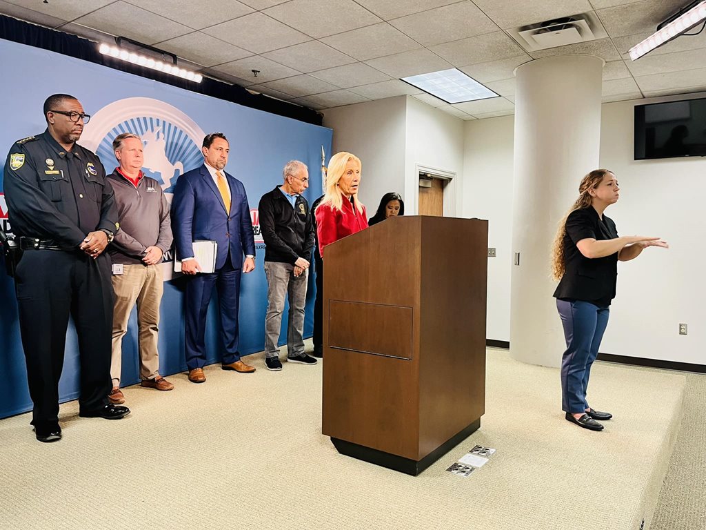 Mayor Deegan and city official standing behind podium at press conference