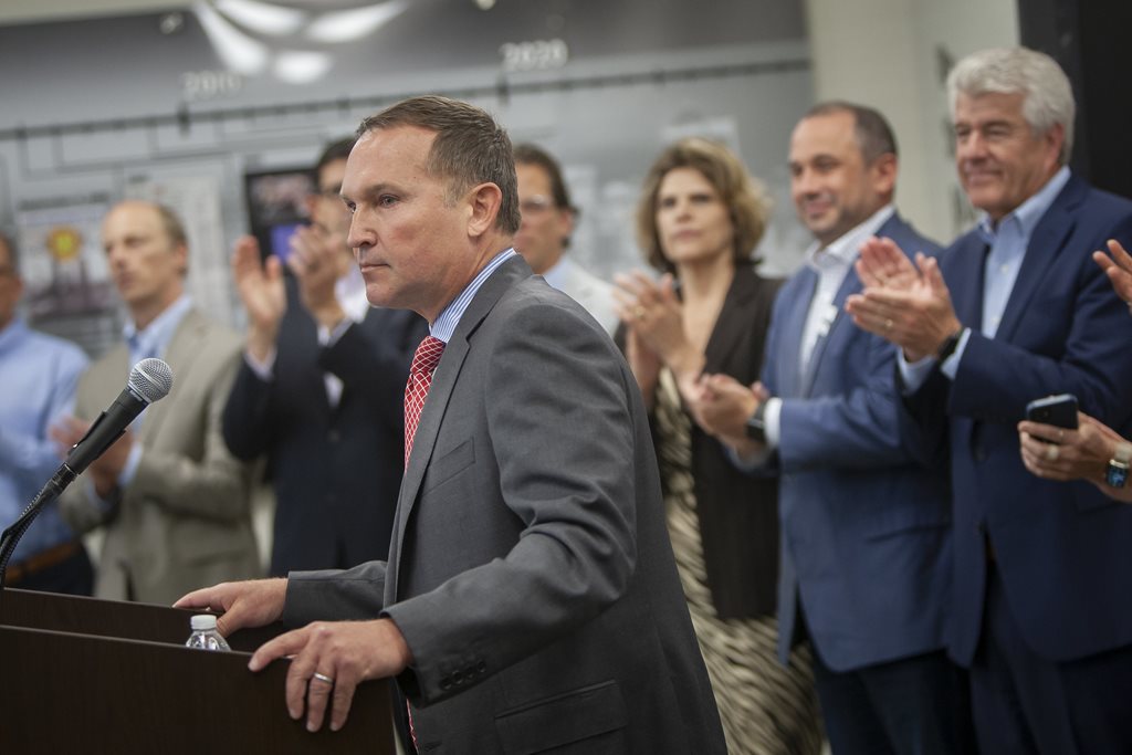 Mayor Curry at podium surrounded by clapping men and women