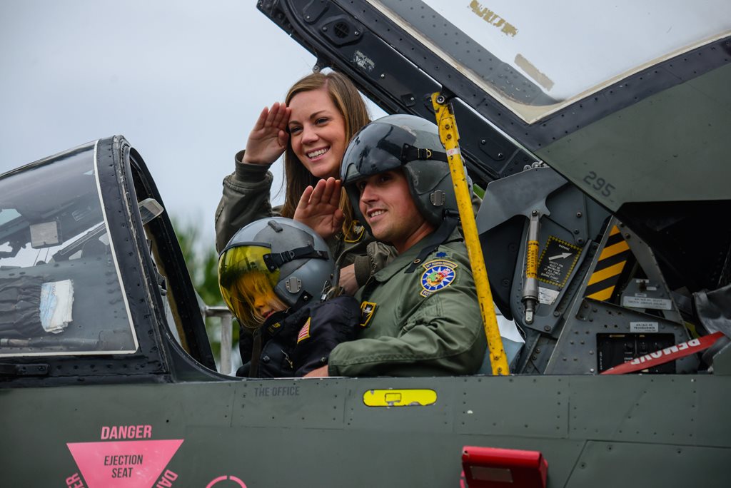 little boy in jet with fighter pilot