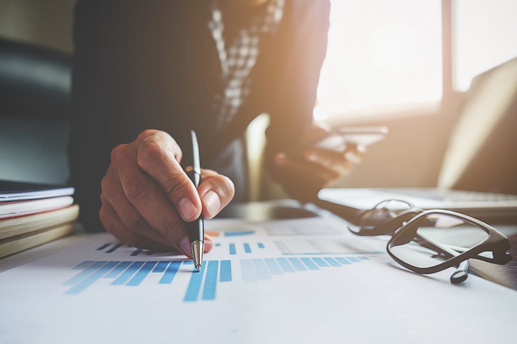 businessman creating a bar graph at his desk