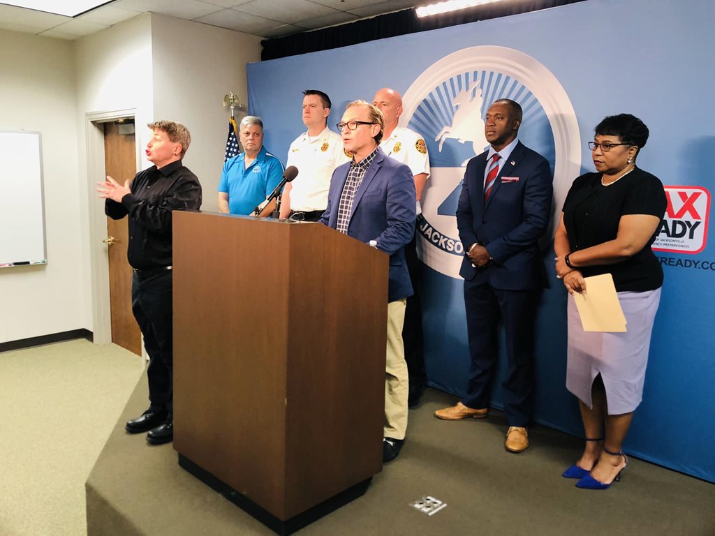 MAYOR CURRY AND OTHERS STANDING BEHIND PODIUM FOR PRESS CONFERENCE