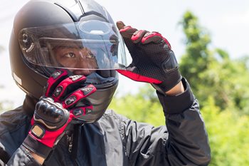 man adjusting mortorcycle helmet