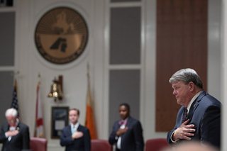 Photo of Council Member Robin Lumb listening to the National Anthem.