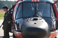 Armed soldier stands next to a helicopter