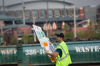 Photo of a worker carrying waste signs.