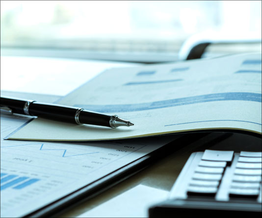 Pen, papers and calculator on top of a desk