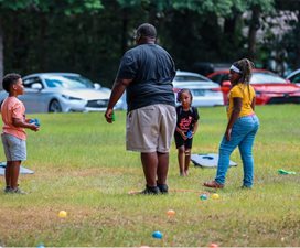 adult and children playing in field