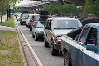 Photo of the long line of cars waiting to dispose of waste tire and signs.