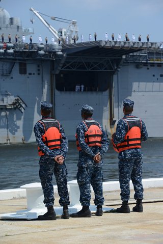 Photo of sailors lining the rail on the USS Iwo Jima as it arrives at Naval Station Mayport.