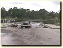 Car putting boat in at boat ramp.