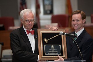 Photo of out-going Council President receiving the "Presidential Gavel Plaque" from in-coming Council President Clay Yarborough.