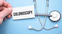 Hand holding a paper written colonoscopy and stethoscope