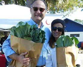 man and woman with paper bags full of collard greens